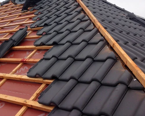 Half gelegd dak met zwarte dakpannen over rode dakfolie in Nieuwegein