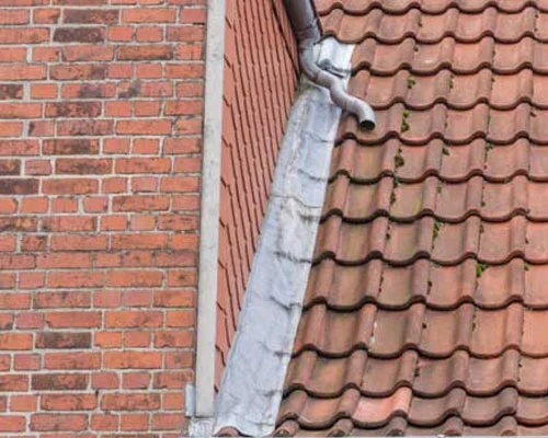Oud loodwerk langs een bakstenen gevel op een rood pannendak in Nieuwegein