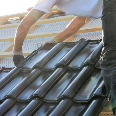 Dakdekker legt nieuwe zwarte dakpannen op panlatten in Houten